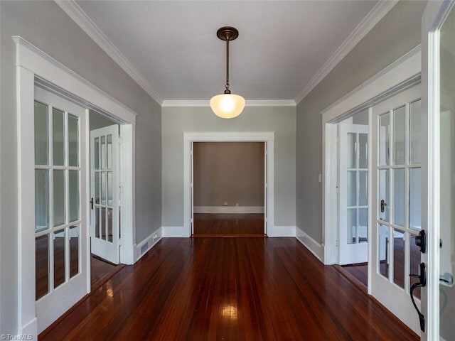 unfurnished dining area with dark hardwood / wood-style floors, crown molding, and french doors