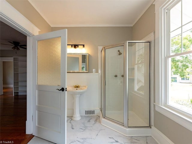 bathroom featuring ceiling fan, a healthy amount of sunlight, an enclosed shower, and ornamental molding