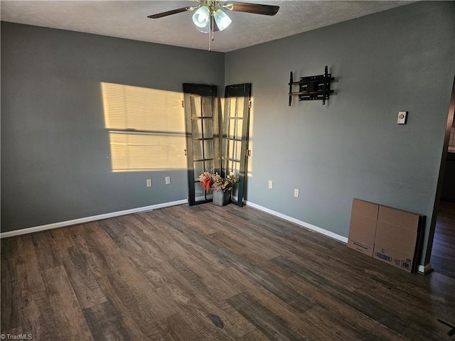 empty room featuring dark hardwood / wood-style floors, a textured ceiling, and ceiling fan