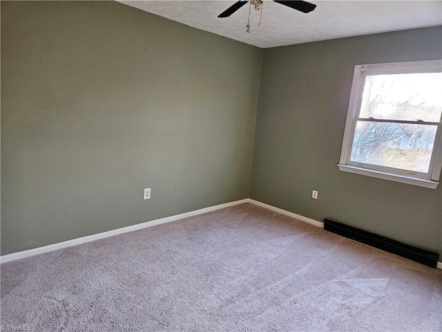 carpeted spare room with a baseboard heating unit and ceiling fan