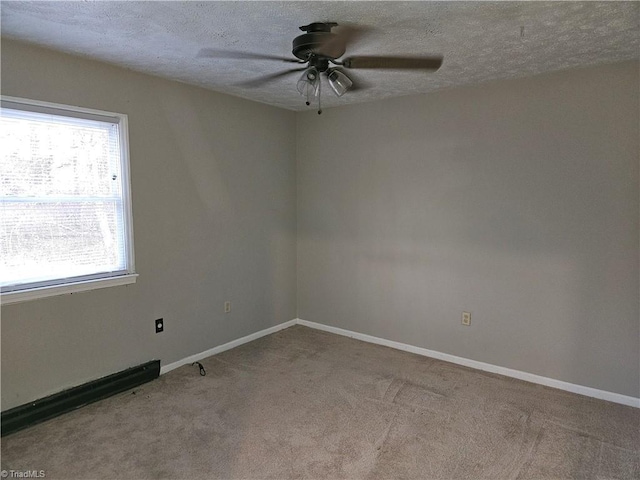 carpeted empty room featuring ceiling fan and a textured ceiling