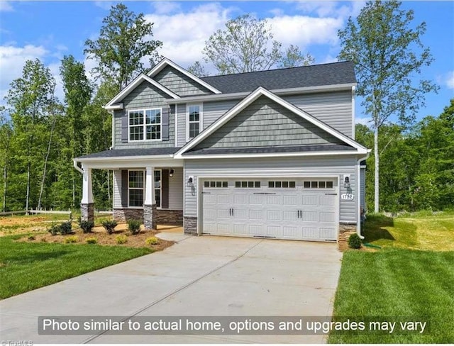 craftsman-style home featuring an attached garage, concrete driveway, a front lawn, and stone siding