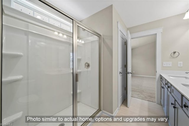 bathroom with walk in shower, hardwood / wood-style floors, and vanity