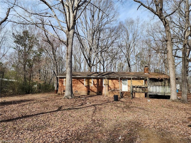 view of front of house featuring crawl space, brick siding, and a chimney