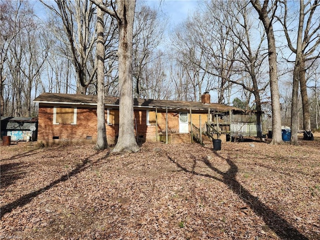 back of house featuring crawl space, a chimney, and brick siding