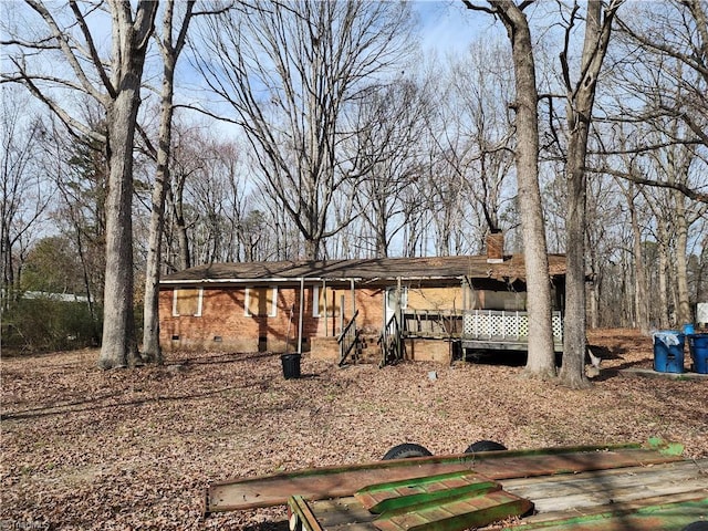 exterior space with brick siding, crawl space, and a chimney