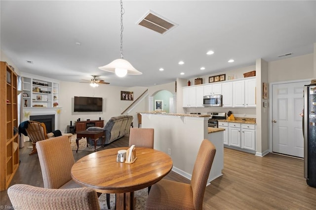 dining space with ceiling fan and dark hardwood / wood-style floors