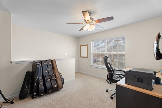 carpeted home office featuring ceiling fan