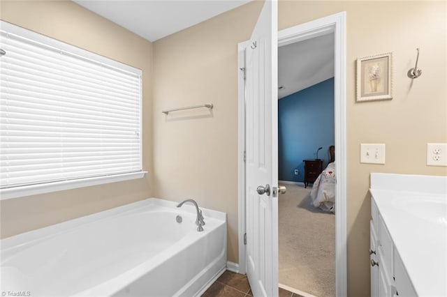 bathroom with tile patterned flooring, vanity, and a tub