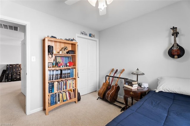 bedroom with ceiling fan, light colored carpet, and a closet