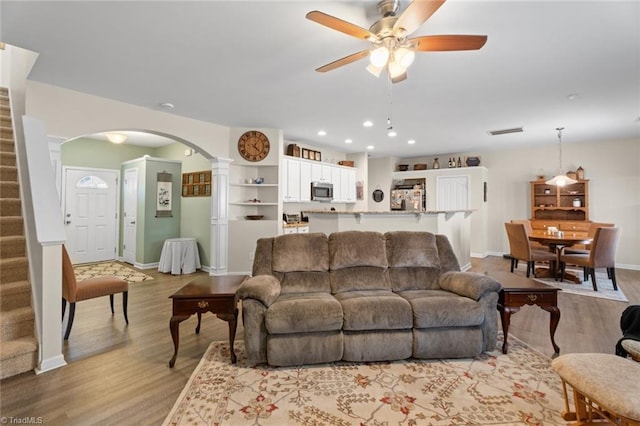 living room featuring light hardwood / wood-style flooring and ceiling fan