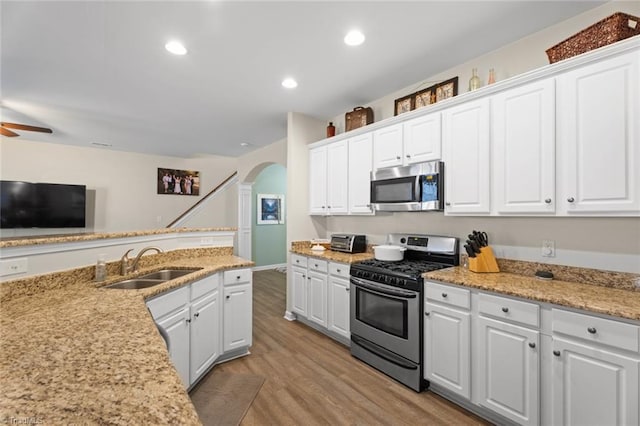 kitchen featuring white cabinets, light wood-type flooring, stainless steel appliances, and sink