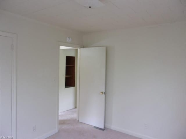 unfurnished room featuring light colored carpet