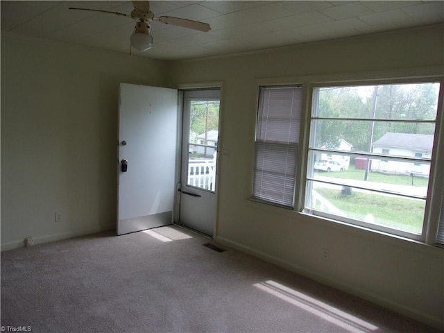 empty room featuring ceiling fan and light carpet