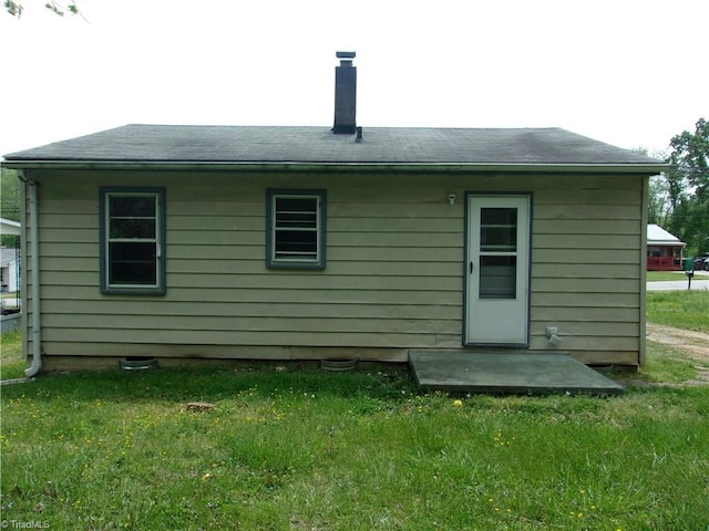 rear view of property featuring a yard