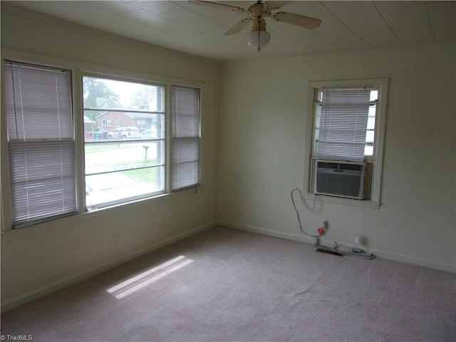 carpeted empty room with ceiling fan and a wealth of natural light