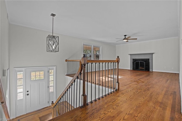 entrance foyer featuring hardwood / wood-style flooring, ornamental molding, and ceiling fan