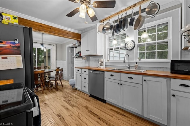 1105 Hawthorne Ln, Burlington, NC 27215 - kitchen featuring butcher block countertops, black appliances, a sink, ornamental molding, and plenty of natural light