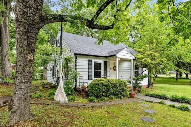 1105 Hawthorne Ln, Burlington, NC 27215 - view of front of house with a front lawn, a shingled roof, and a chimney