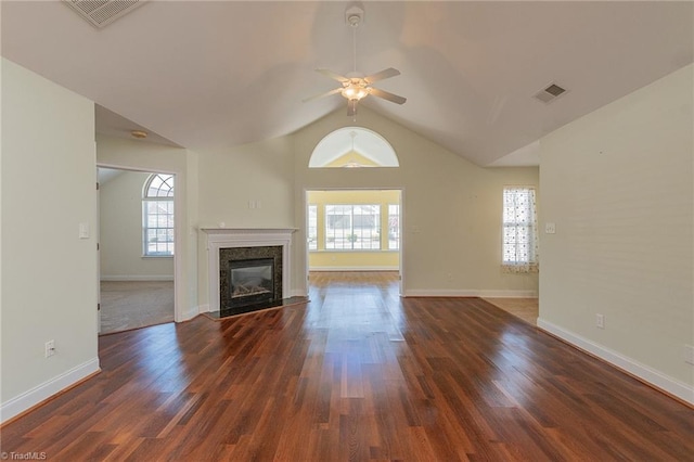 unfurnished living room with vaulted ceiling, a ceiling fan, a premium fireplace, and visible vents