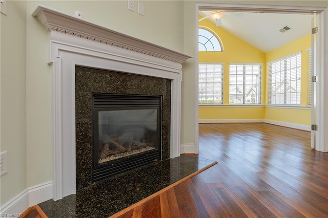 details with ceiling fan, visible vents, a high end fireplace, wood finished floors, and baseboards