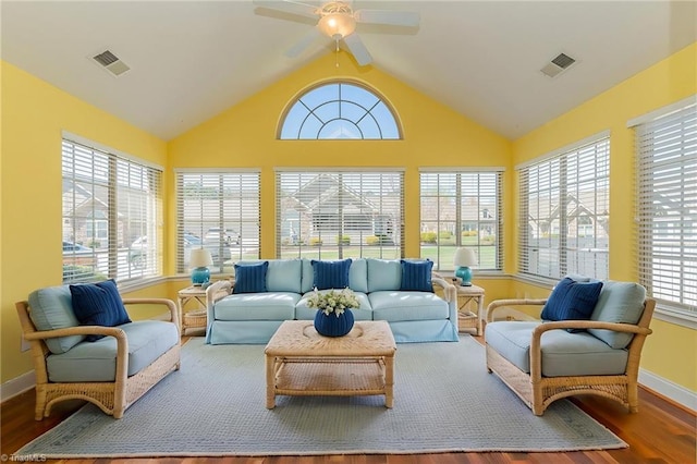 sunroom / solarium with baseboards, wood finished floors, and visible vents