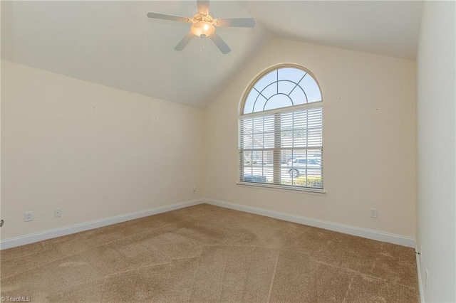 carpeted empty room featuring a ceiling fan, baseboards, and vaulted ceiling
