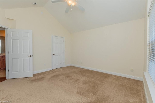 unfurnished bedroom featuring light colored carpet, baseboards, ceiling fan, and high vaulted ceiling