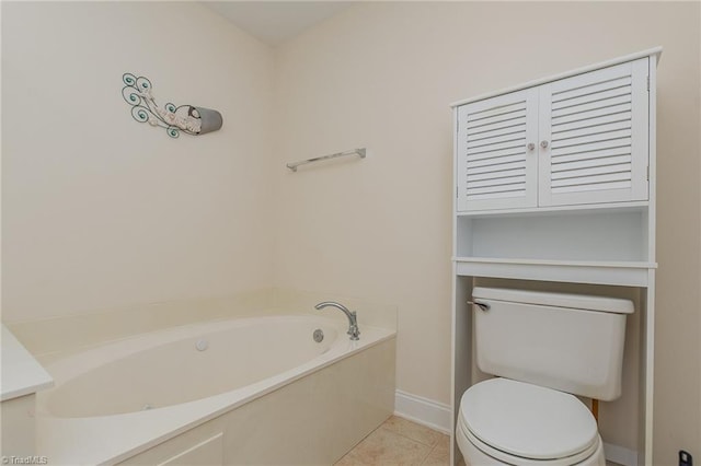 bathroom featuring tile patterned floors, baseboards, a garden tub, and toilet