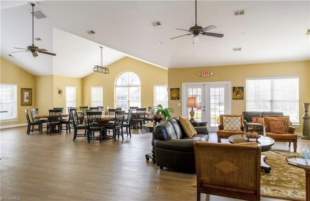 living room with ceiling fan, visible vents, and wood finished floors