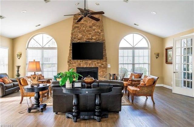 living room with a ceiling fan, wood finished floors, and a healthy amount of sunlight