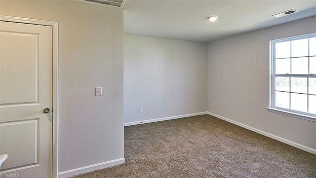 spare room with a wealth of natural light and carpet floors