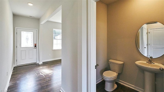 bathroom featuring toilet, wood-type flooring, sink, and beamed ceiling