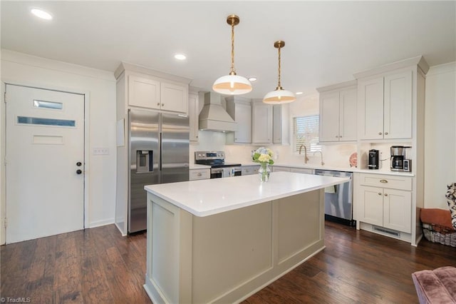 kitchen with a center island, dark wood-style flooring, light countertops, appliances with stainless steel finishes, and premium range hood