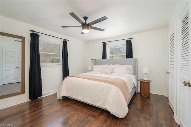 bedroom with baseboards, visible vents, a ceiling fan, wood finished floors, and a closet