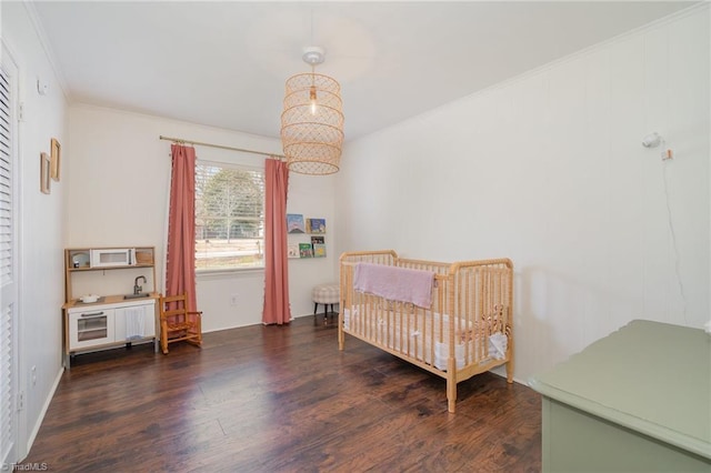 bedroom featuring a chandelier, ornamental molding, and wood finished floors