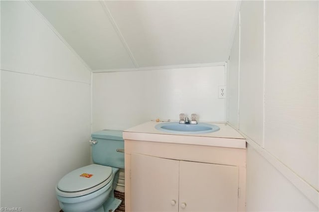 bathroom featuring lofted ceiling, toilet, and vanity