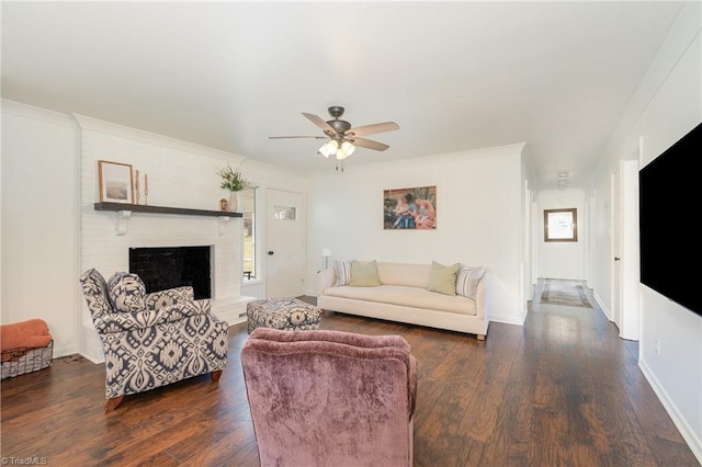 living room featuring a fireplace, dark wood finished floors, a ceiling fan, ornamental molding, and baseboards