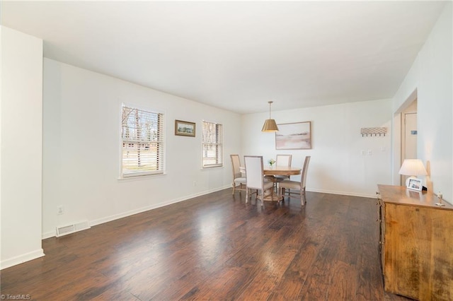 dining space featuring dark wood-style flooring, visible vents, and baseboards