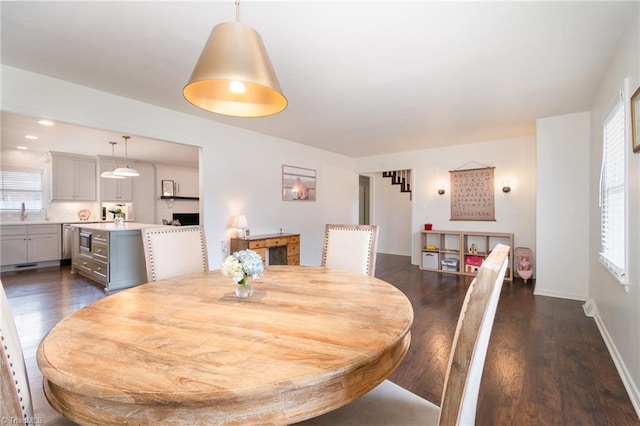 dining area featuring baseboards, dark wood-type flooring, and a wealth of natural light