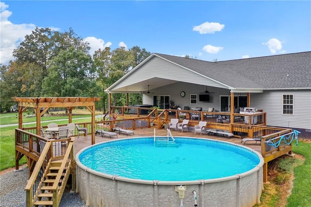 view of swimming pool with a wooden deck, ceiling fan, and a pergola