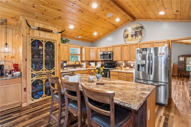 kitchen featuring appliances with stainless steel finishes, sink, lofted ceiling with beams, a center island, and dark hardwood / wood-style floors