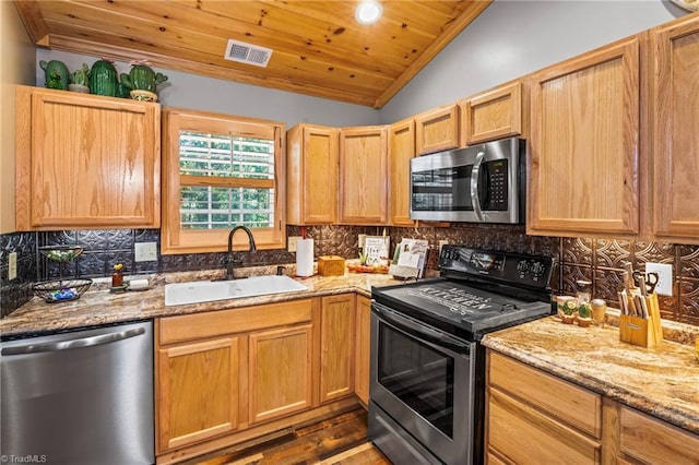 kitchen with tasteful backsplash, light stone countertops, vaulted ceiling, sink, and stainless steel appliances