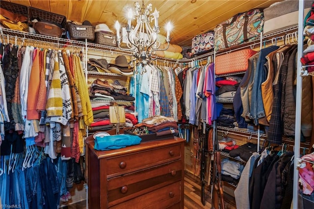 walk in closet featuring a notable chandelier and hardwood / wood-style flooring