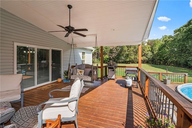 wooden terrace featuring a yard, a swimming pool, and ceiling fan