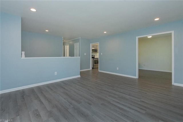 spare room with baseboards, dark wood-style floors, and recessed lighting