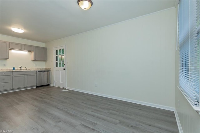 kitchen featuring a sink, gray cabinets, dark wood-style flooring, light countertops, and stainless steel dishwasher