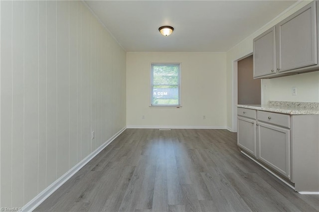 unfurnished dining area with baseboards and wood finished floors