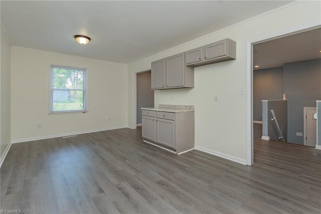 kitchen with baseboards, light countertops, gray cabinets, and wood finished floors