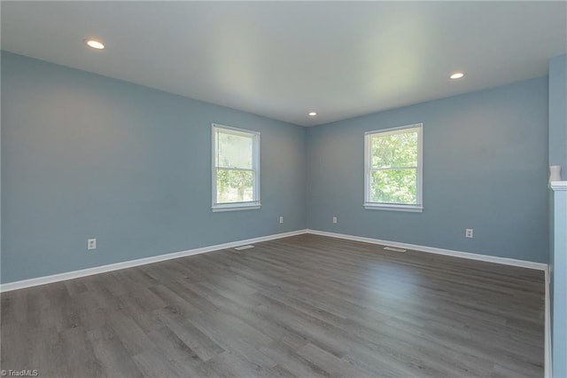 unfurnished room with dark wood-style flooring, baseboards, and recessed lighting